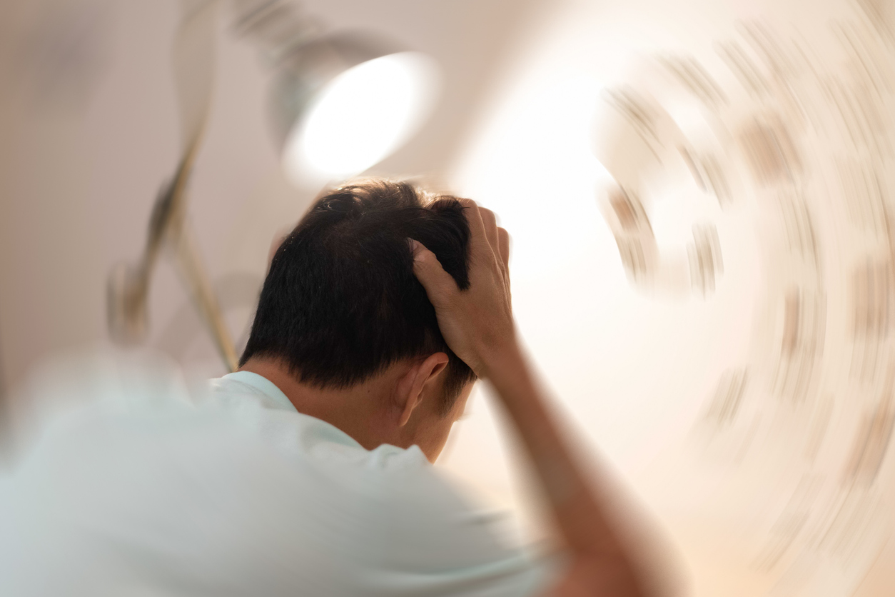 Man grijpt aan zijn hoofd in een omgeving die lijkt te draaien.